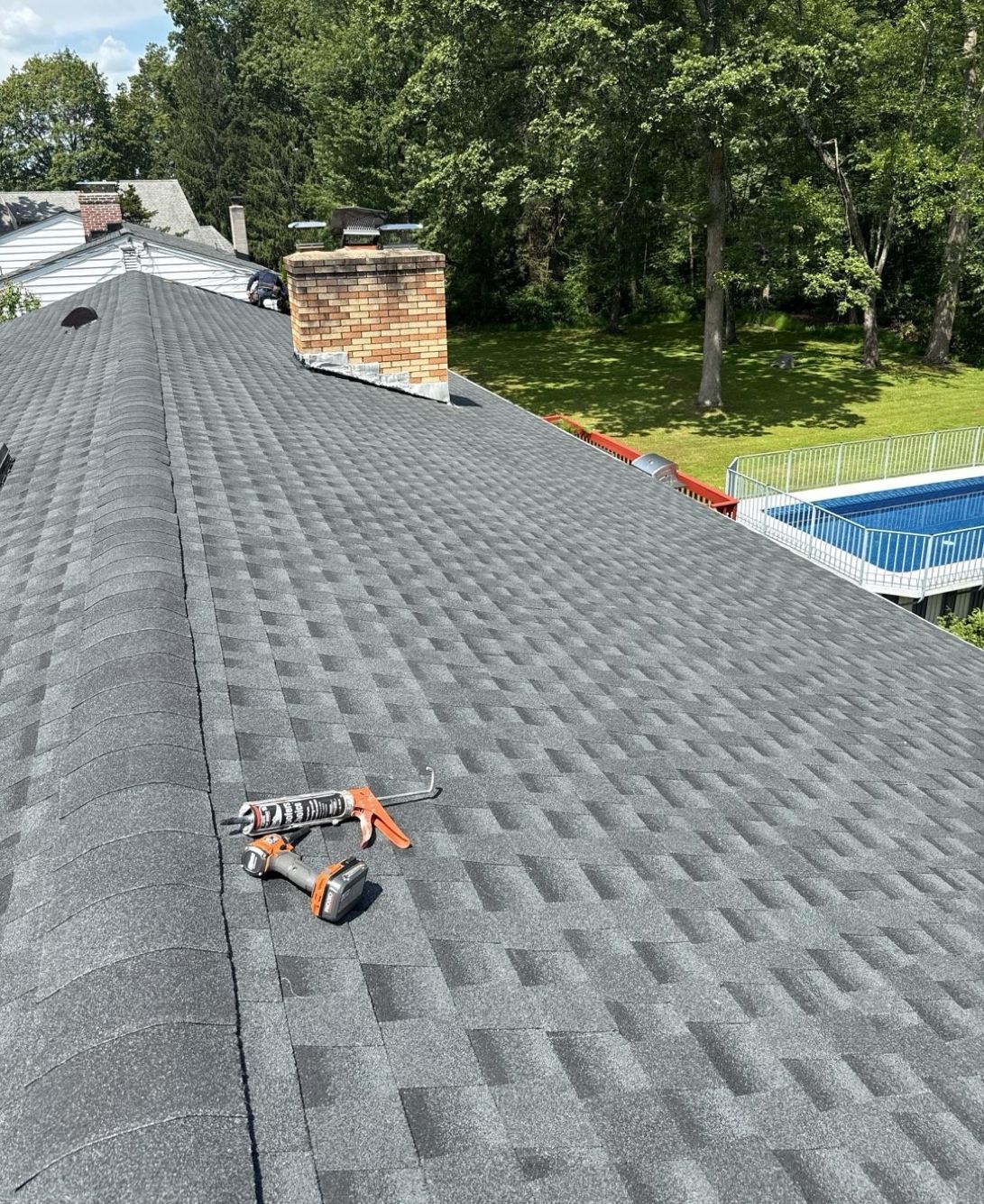 Gray shingled roof with repair tools visible.